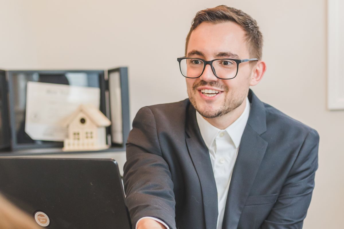 Agente inmobiliario atendiendo a un cliente en la oficina