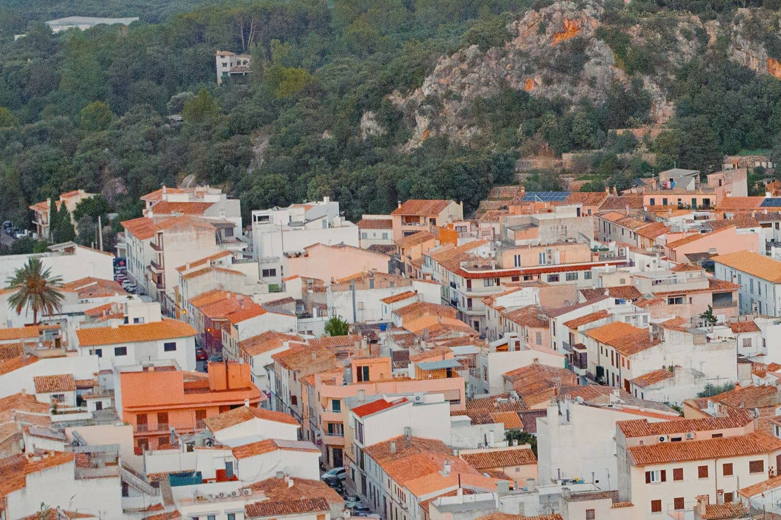 An aerial view of a Spanish town with red tiled roofs