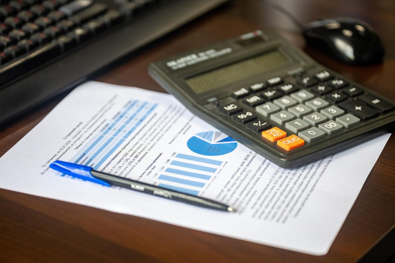 A calculator on a financial report with charts