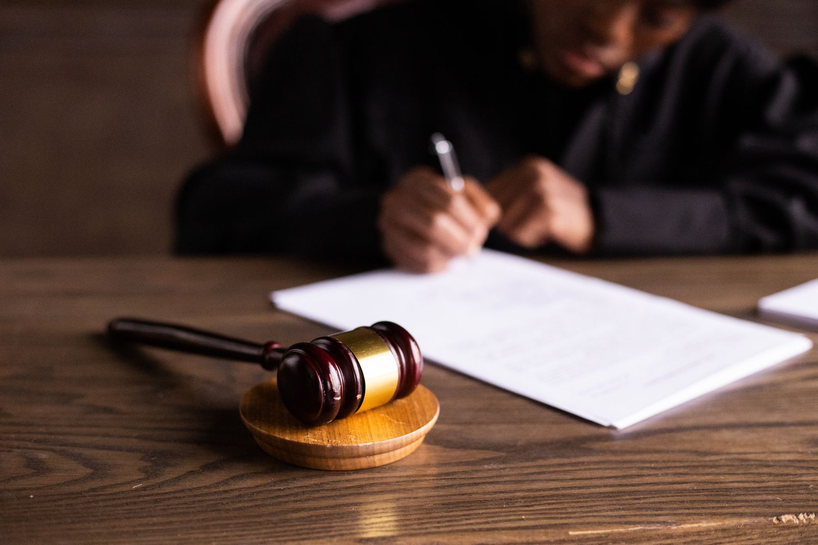A judge signs documents beside a gavel