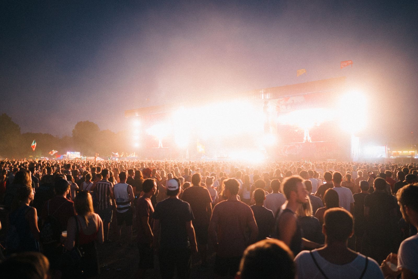 A music festival crowd under stage lights at night