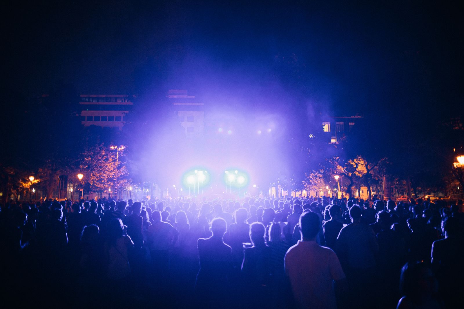 An open-air summer concert crowd at night