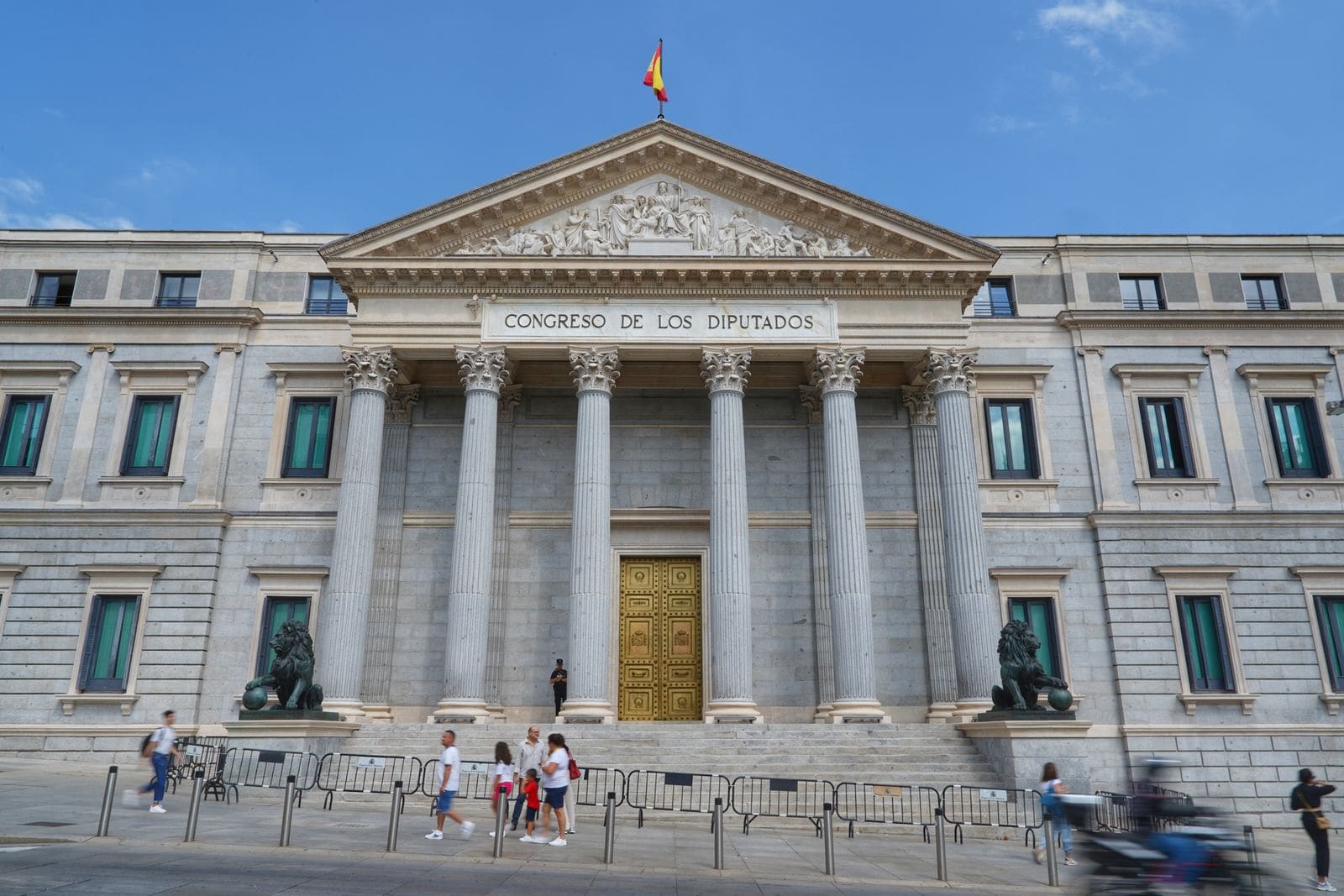 The Congreso de los Diputados building in Madrid, with its columns, bronze lions and the Spanish flag