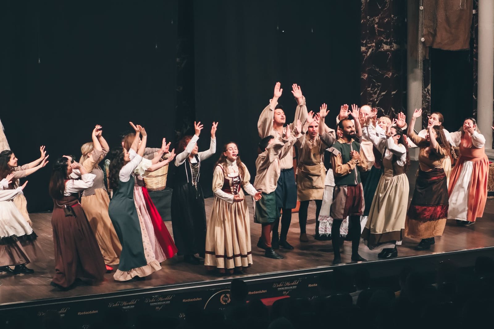 Performers in costume on a theatre stage